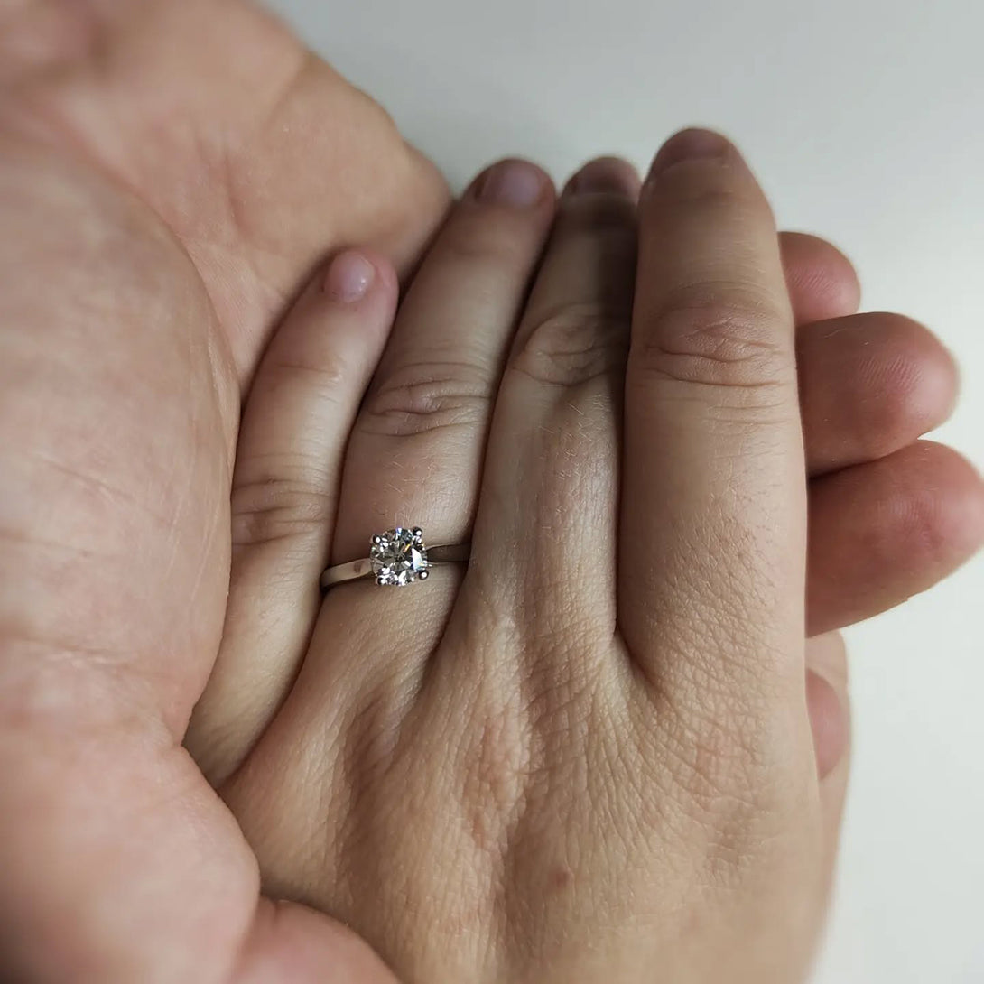 Two hands holding, one hand wearing an engagement ring